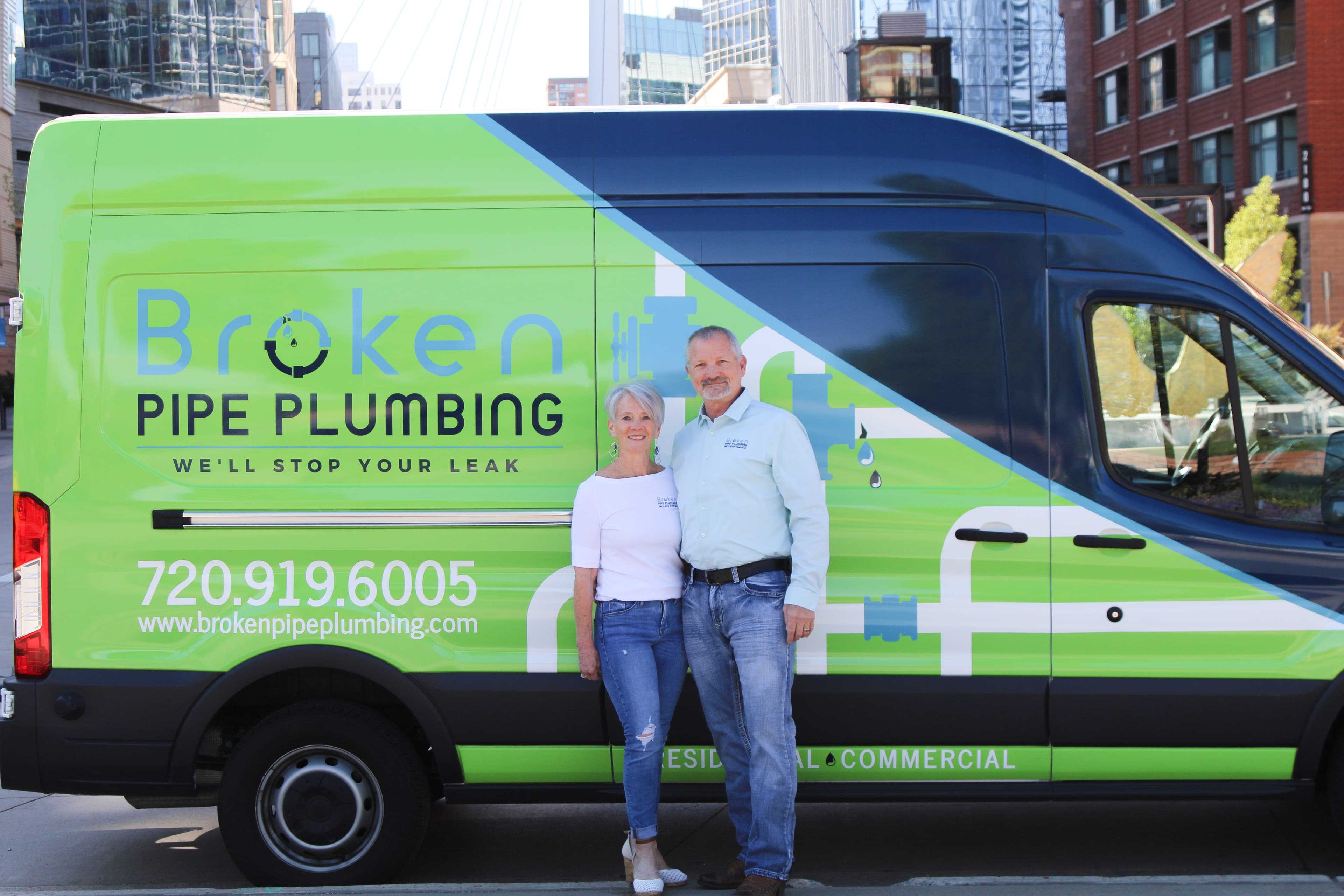 Wayne and Sandy Schafer standing in front of the Broken Pipe Plumbing van in downtown Denver